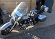 A motorcycle parked in the street with another person standing next to it.