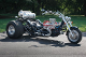 A motorcycle with a big tire parked on the side of the road.