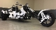 A white and black three wheeled motorcycle parked in a garage.