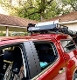 A red truck with a roof rack and a bike carrier on top.