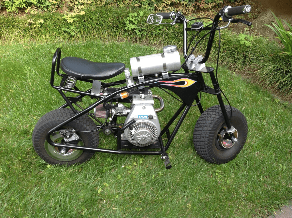 A black and silver motorcycle sitting in the grass.
