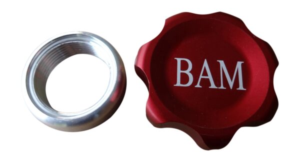 A red cap and a silver ring with the word bam on it.