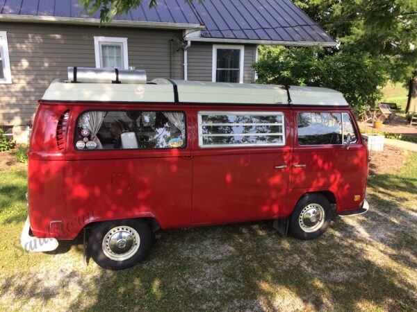 A red van parked in front of a house.