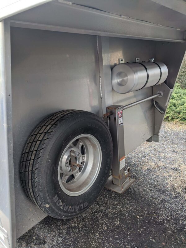 A tire on the side of a trailer.