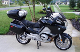 A black motorcycle parked in the driveway of a house.
