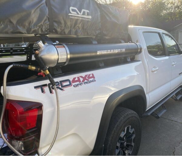 A white truck with a black canopy on the back of it.