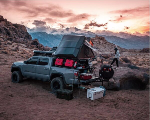 A truck with an open tent on the back of it.