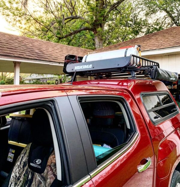 A red truck with a roof rack on it.