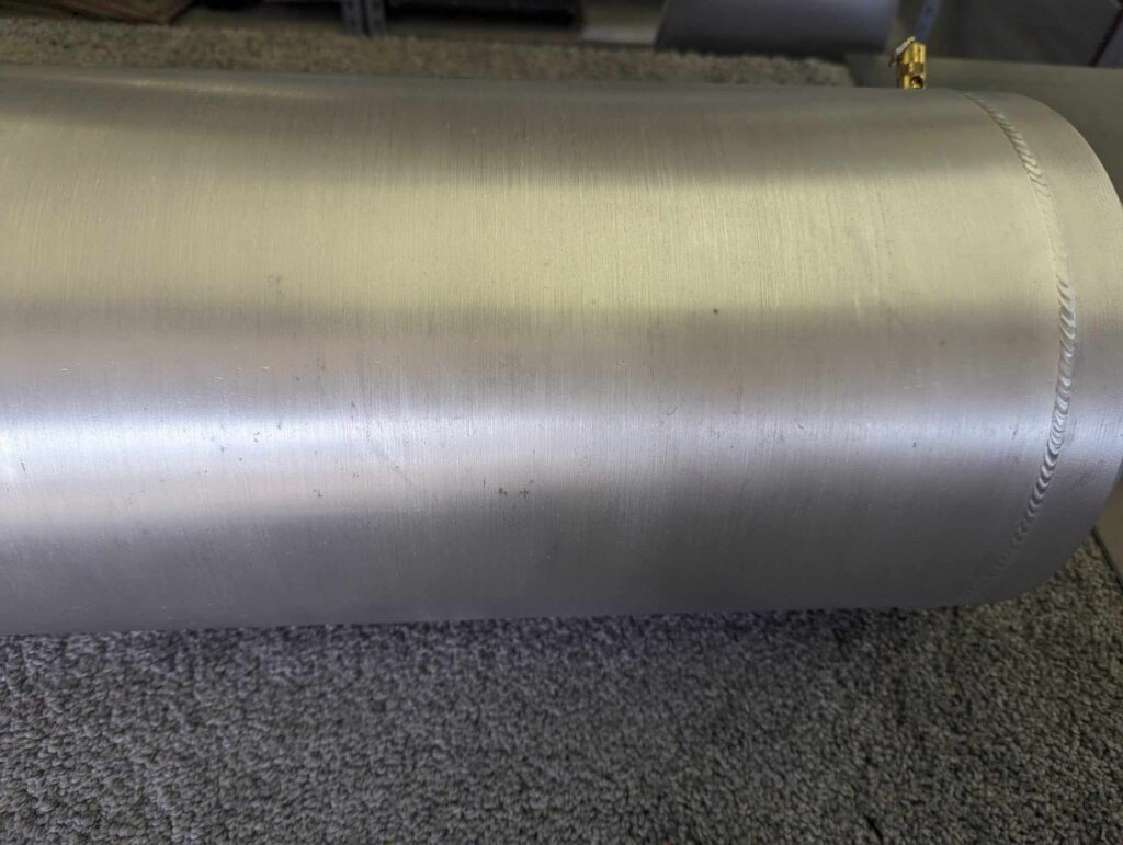 A metal tube sitting on top of the carpet.